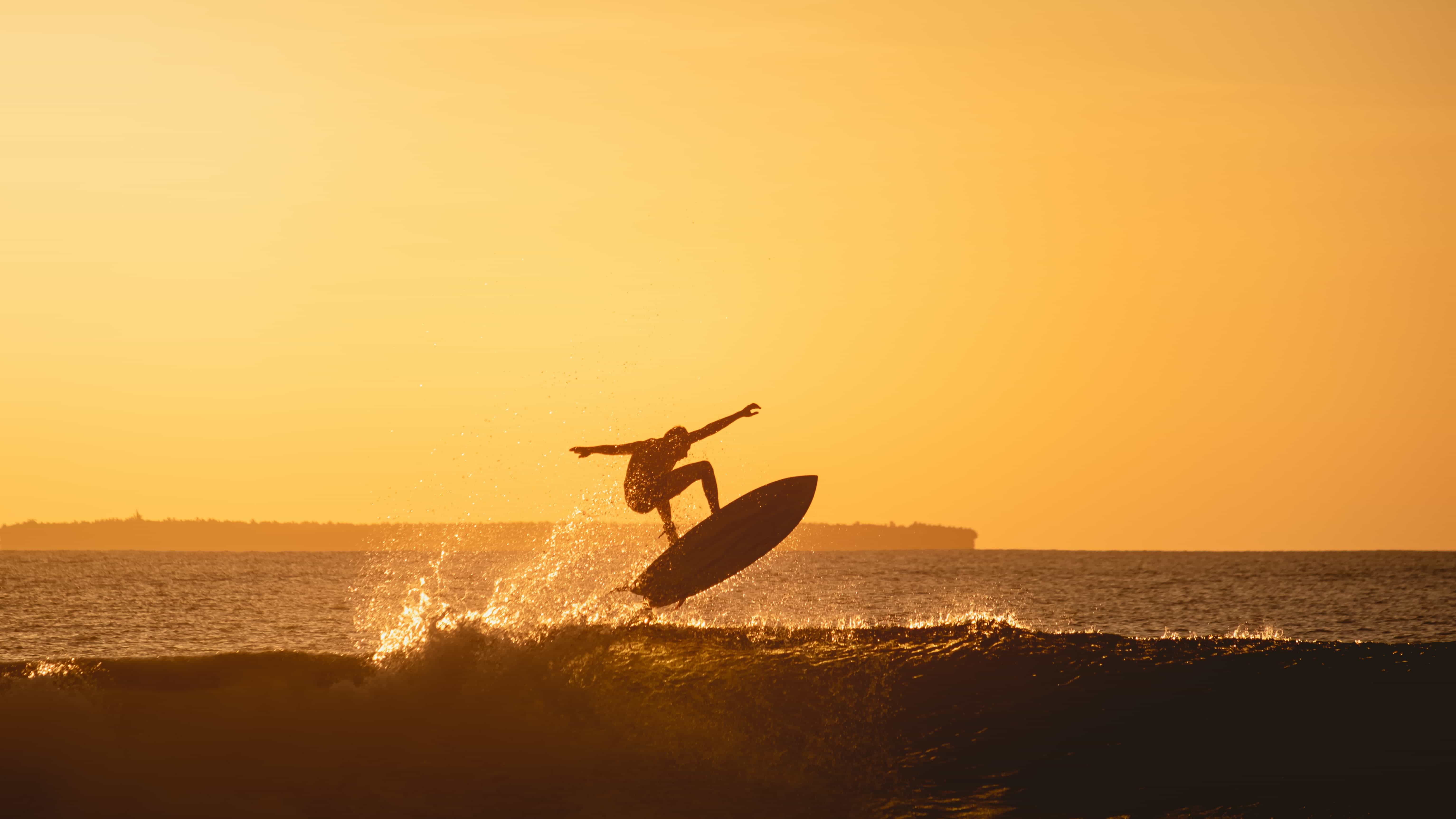 Surfer dropping into a reef wave in the Maldives