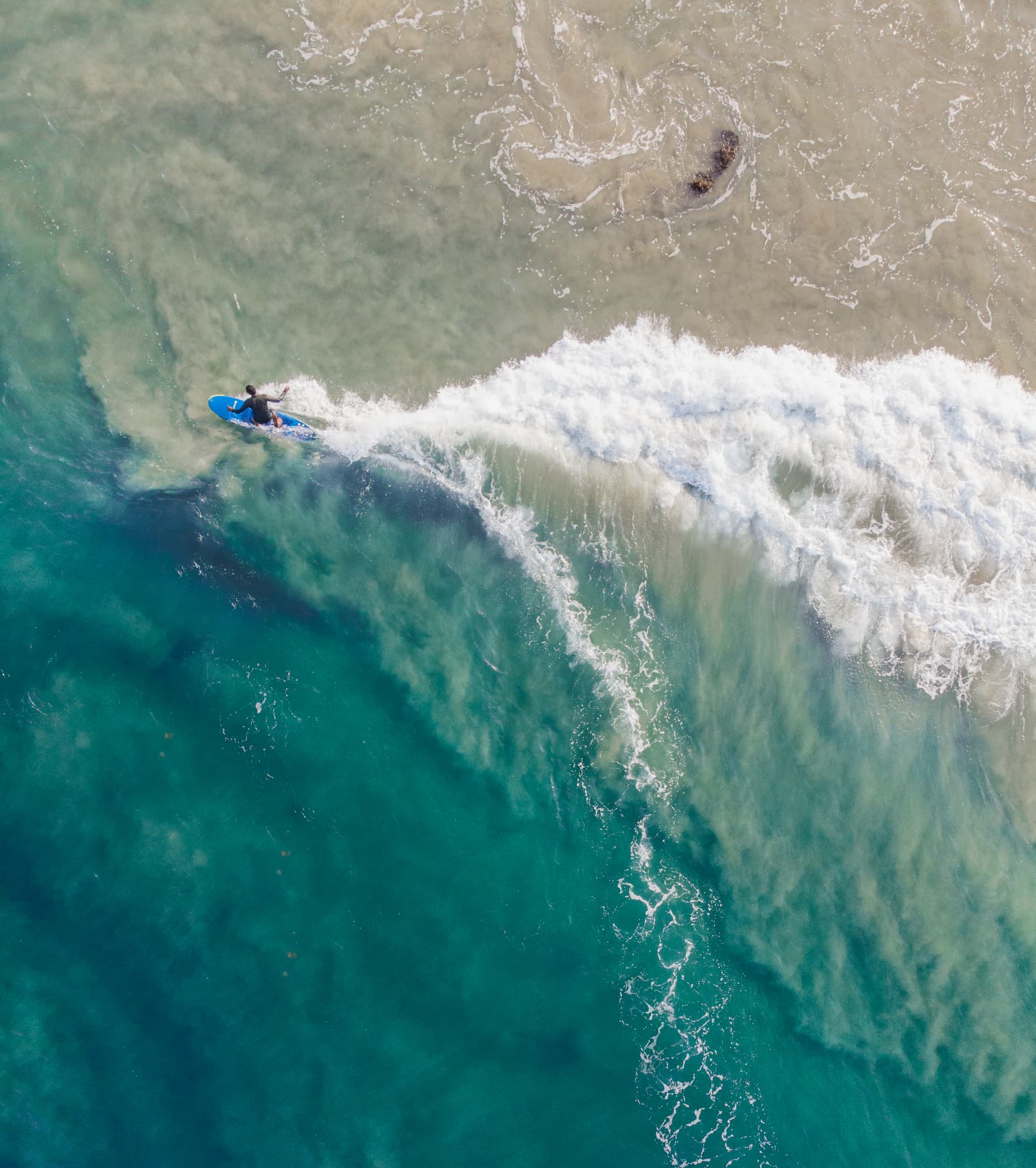 Drone shot of a surf line-up over a coral reef